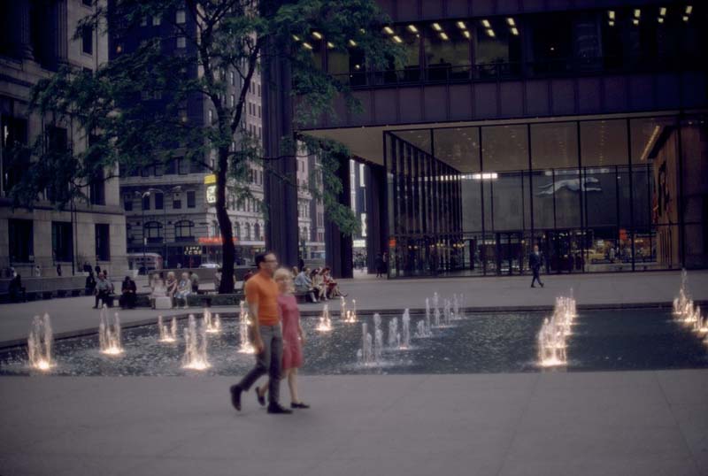 couple walking in plaza with fountains