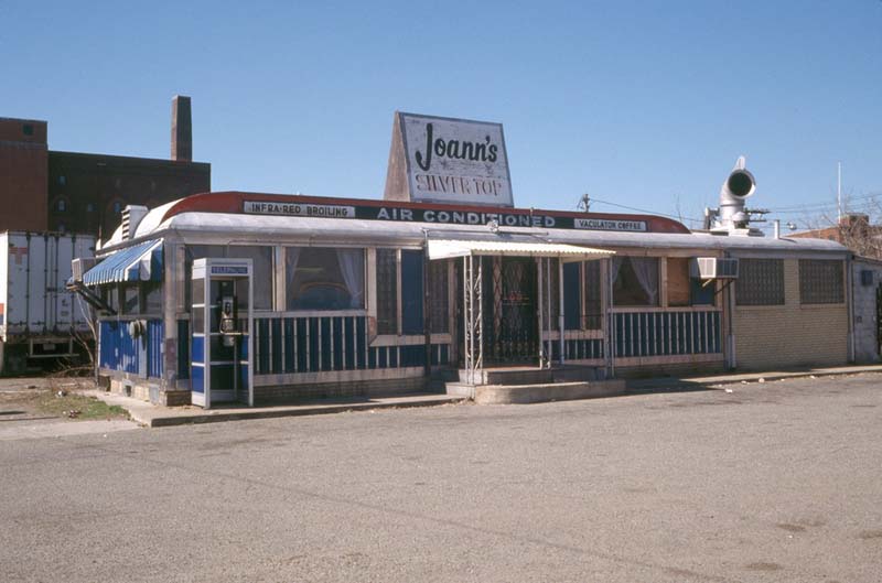 a diner car with a sign on top that reads Joann's Silver Top, asphalt foreground