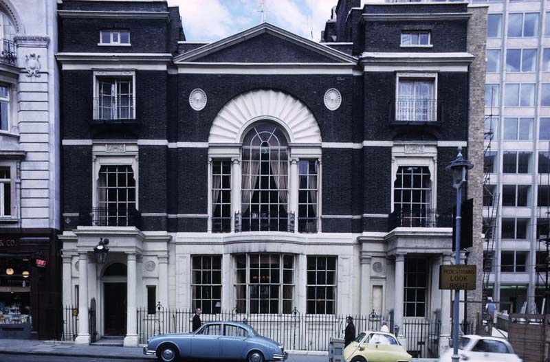 white and black building with cars parked on street