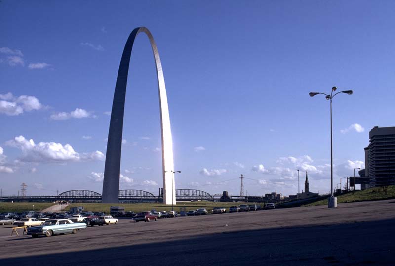 tall metal arch, highway and cars in foreground