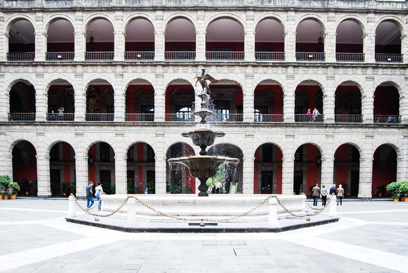 fountain in front of arcaded building