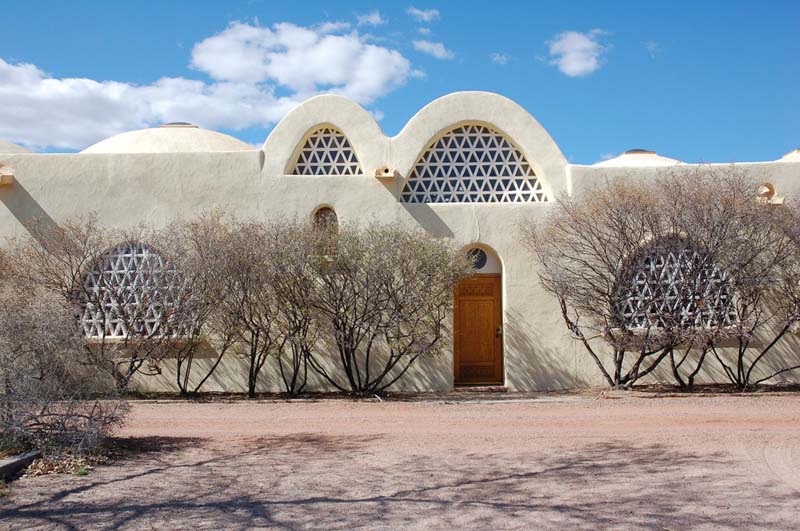 white mud brick building with arches with lattice screens
