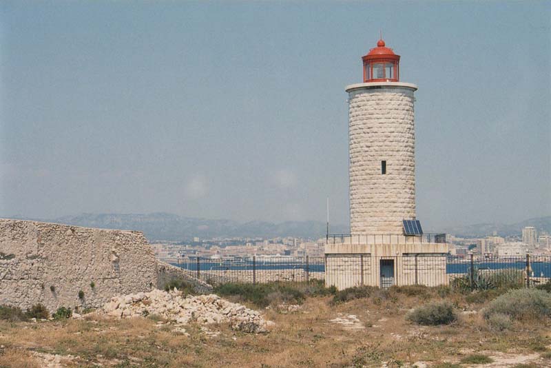 lighthouse with white stone tower and red lantern room