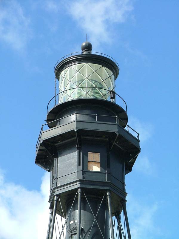 detail of black metal lighthouse withe lantern room with diagonal metal muntins