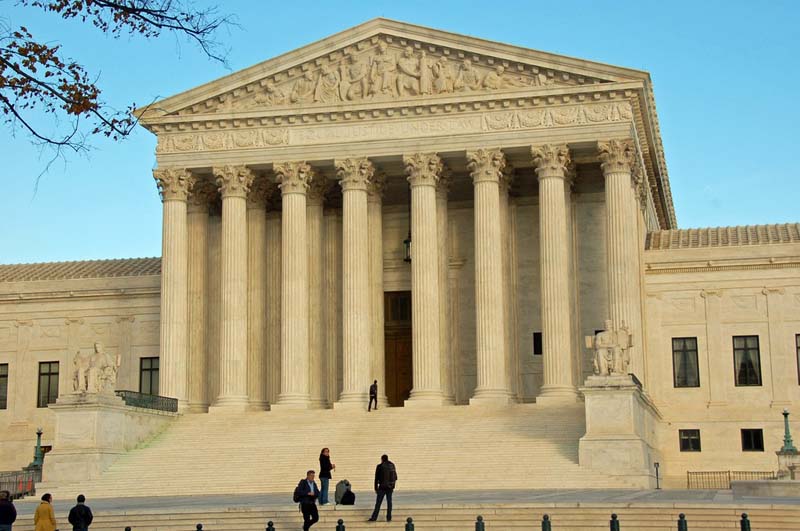 A few visitors linger on the steps leading up to the US Supreme Court