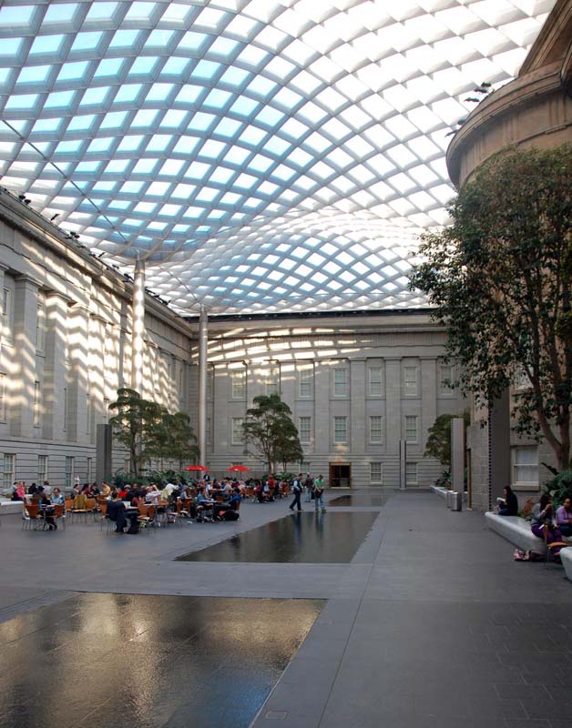 A curving roof of diamond glass panels covers a gallery in the Smithsonian's American Wing