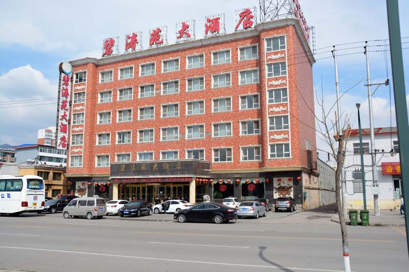 a six-story brick building with large red characters on the rooftop signage