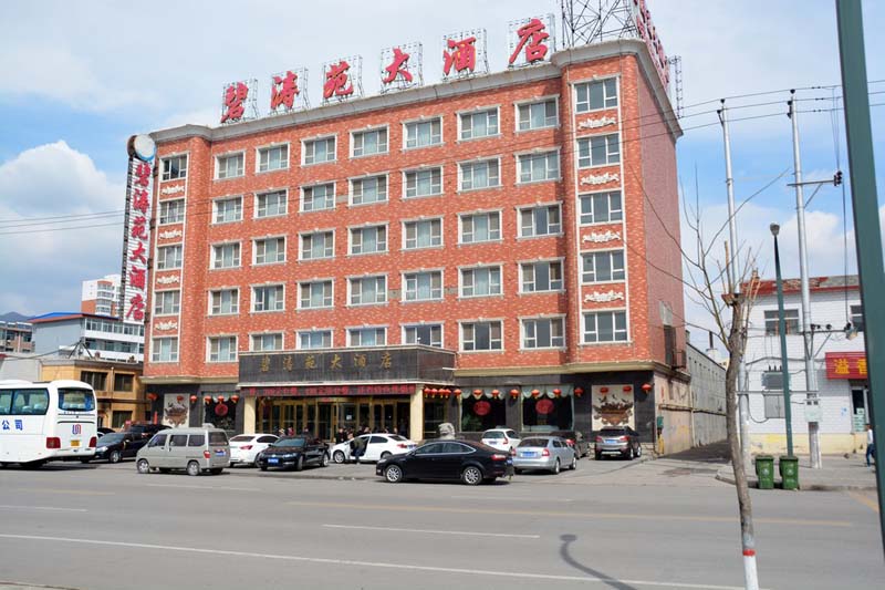 Bitaoyuan Hotel a six-story brick building with large red characters on the rooftop signage