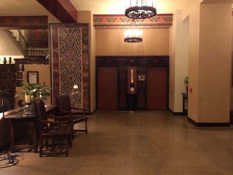 a small lobby with geometric tapestries decorating the walls.