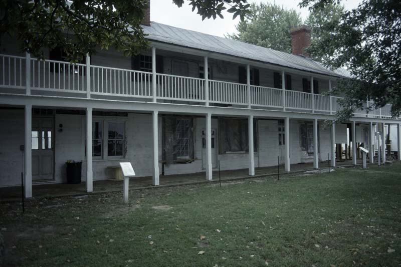 a long, white, two-story building with external breezeways