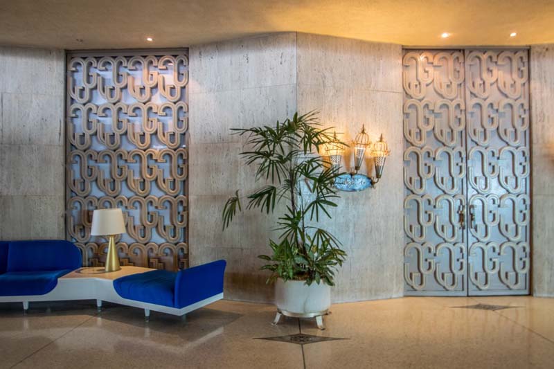 Hotel Havana Riviera a lobby with a blue and white modernist bench and patterned doors and wall panels