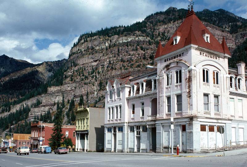 a white building with red roof in a mountain setting