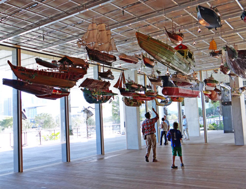 Figure 7- “For Those in Peril on the Sea”, Hew Locke, 79 boats suspended in an anchor gallery in PAMM on main floor with windowed walls and views to Miami